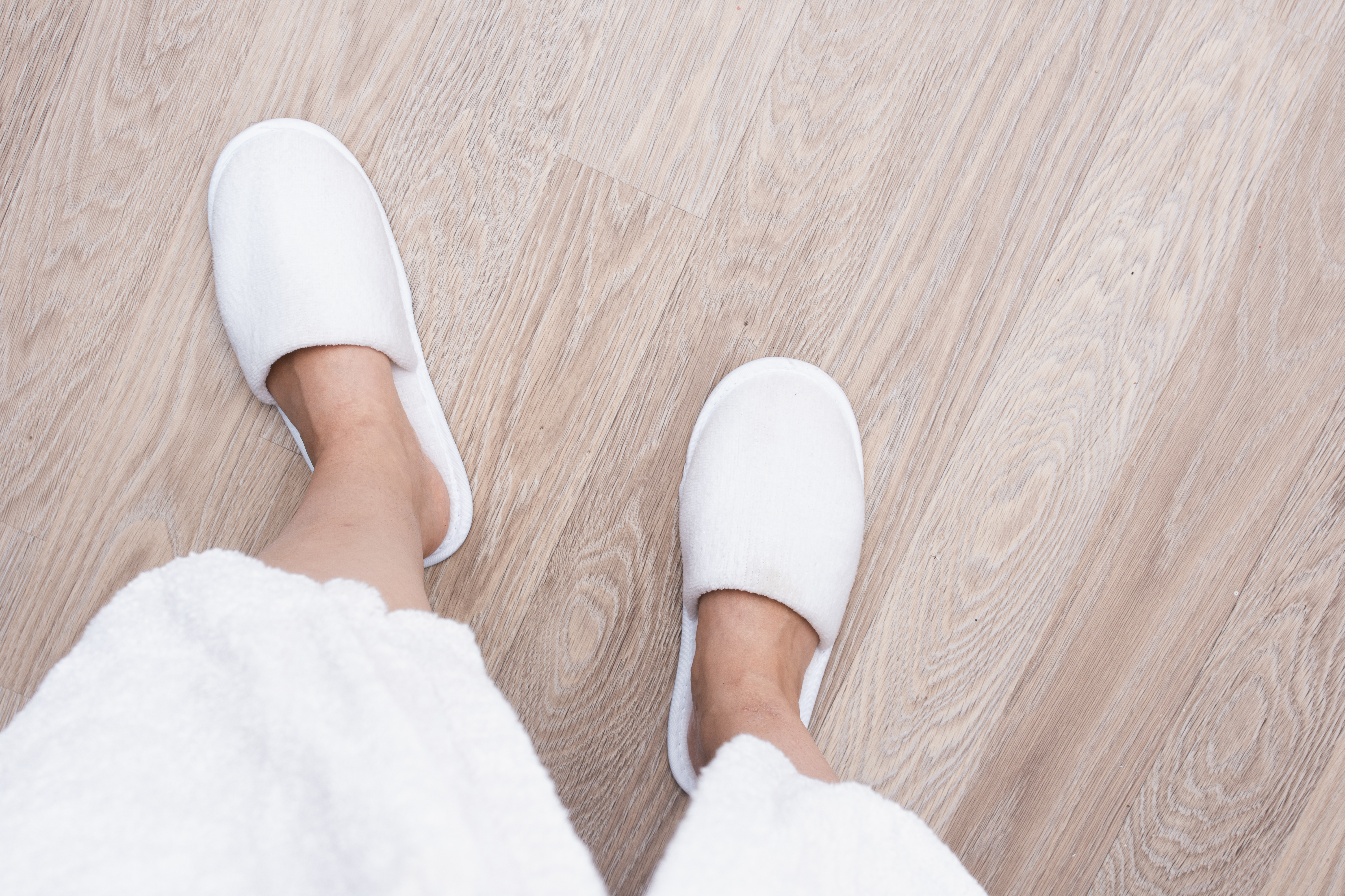 close-up-person-with-white-shoes-wooden-floor